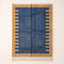 Denim and camel Mrirt rug with comb-edge border motif on plain background, flat lay