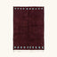 Full view of the Idir burgundy Beni Ourain rug with a rich border block motif and hand-tied fringe.