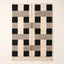 Ivory, black and grey Beni Ourain rug with checkerboard blocks pattern, flat lay on plain background