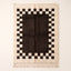 Ivory and charcoal Beni Ourain rug with checkerboard border, full flat view