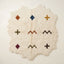 Ivory Beni Ourain rug with irregular wavy edges, scattered with terracotta diamond, navy diamond, gold cross, olive cross, rust chevrons, burgundy diamond, and dark olive chevron and dark cross motifs