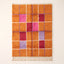 Orange, hot pink, deep red and purple Mrirt rug with geometric window grid pattern separated by white and periwinkle lines, flat view on plain background with cream fringe