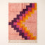 Rose Mrirt rug with stair-step motif in plum, hot pink, orange and gold, flat lay on plain background