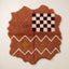 Terracotta Azilal rug with scalloped edges, featuring a burgundy and ivory checkerboard panel at the top, white zigzag bands, and a small golden-yellow diamond accent below
