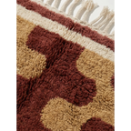 Border detail of the Aderfi abstract Beni Ourain rug in terracotta, camel and ivory.