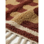 Close-up of the Aderfi rug's dense terracotta and camel wool pile.