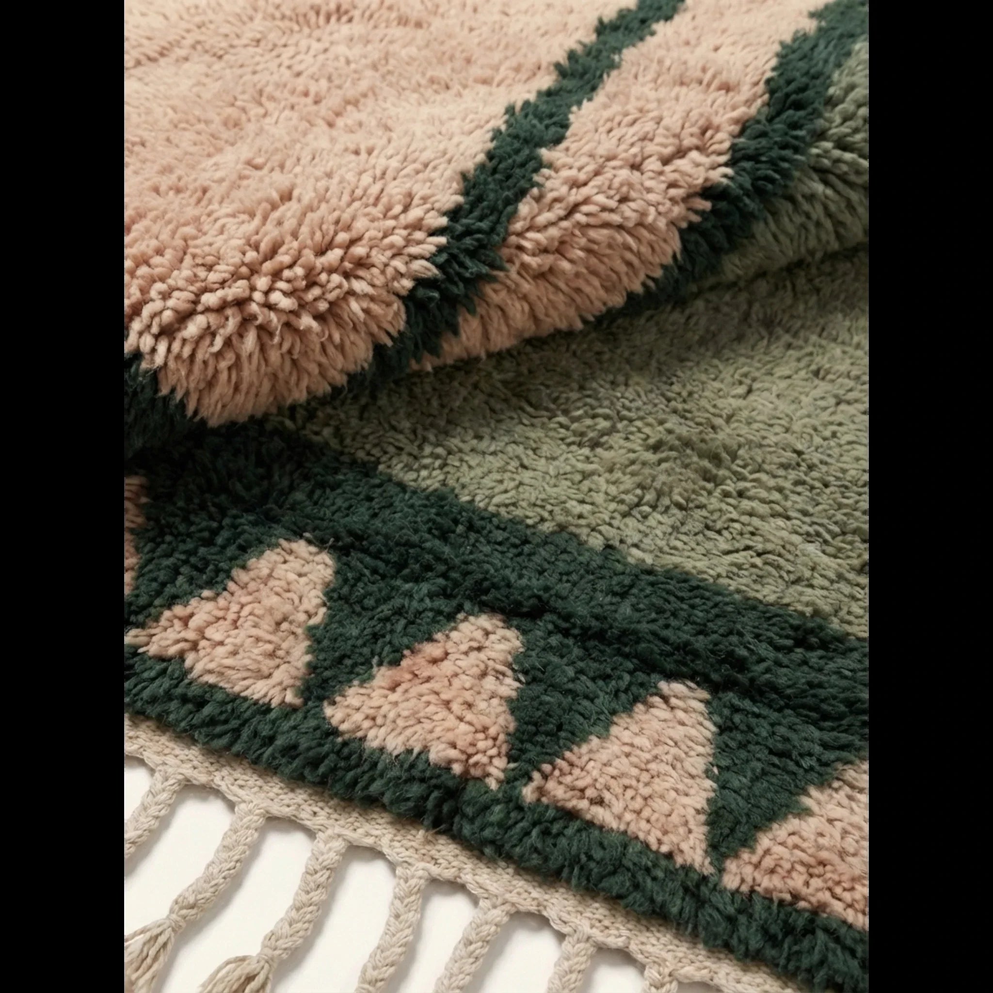 Close-up of the olive and ivory framed triangle motif on the Agbalou rug.