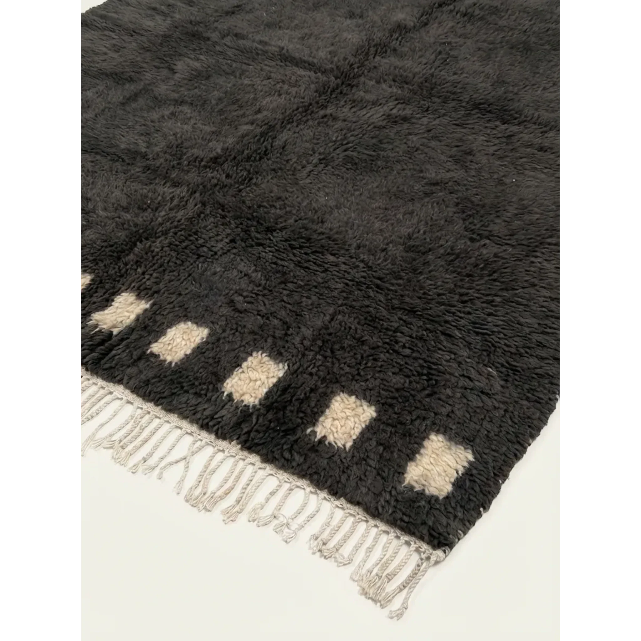 Hand-tied fringe and plush wool detail of the Amanar charcoal rug.
