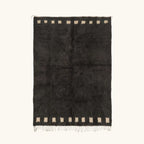 Full view of the Amanar charcoal Beni Ourain rug with a bold border block motif and hand-tied fringe.