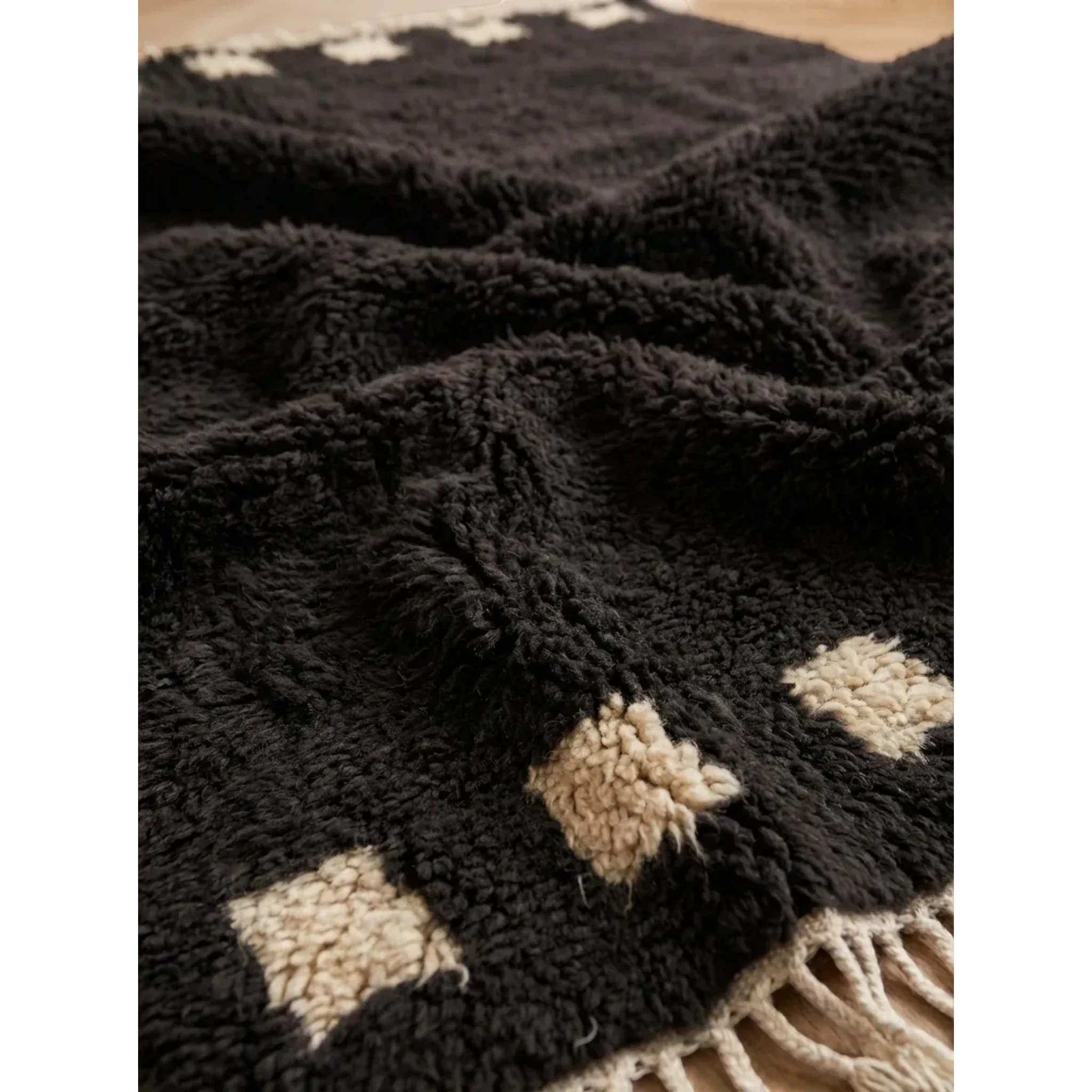 Close-up of the dense charcoal and ivory Atlas wool pile on the Amanar rug.