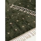 Hand-tied ivory fringe and green wool pile detail of the Amnay rug.