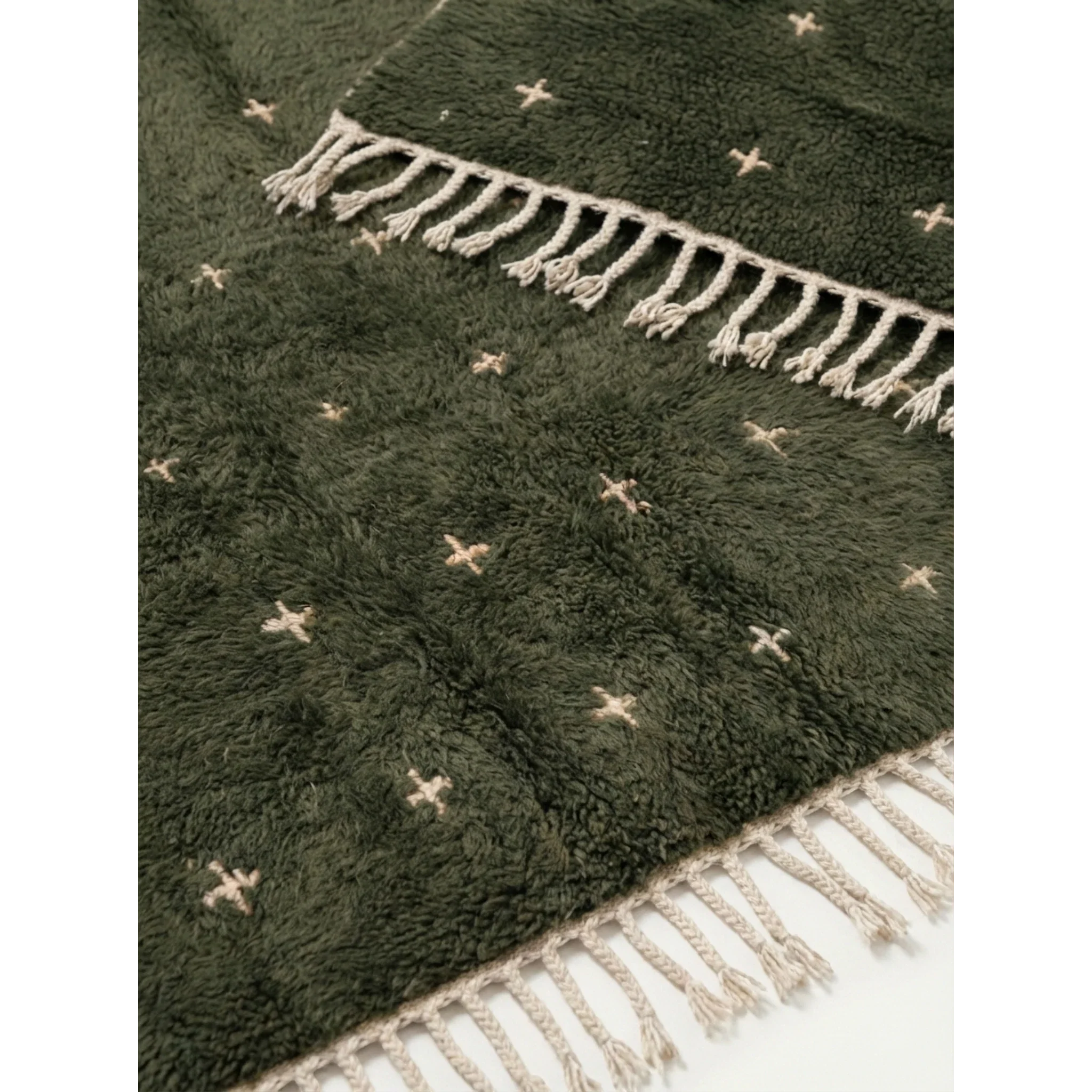 Hand-tied ivory fringe and green wool pile detail of the Amnay rug.