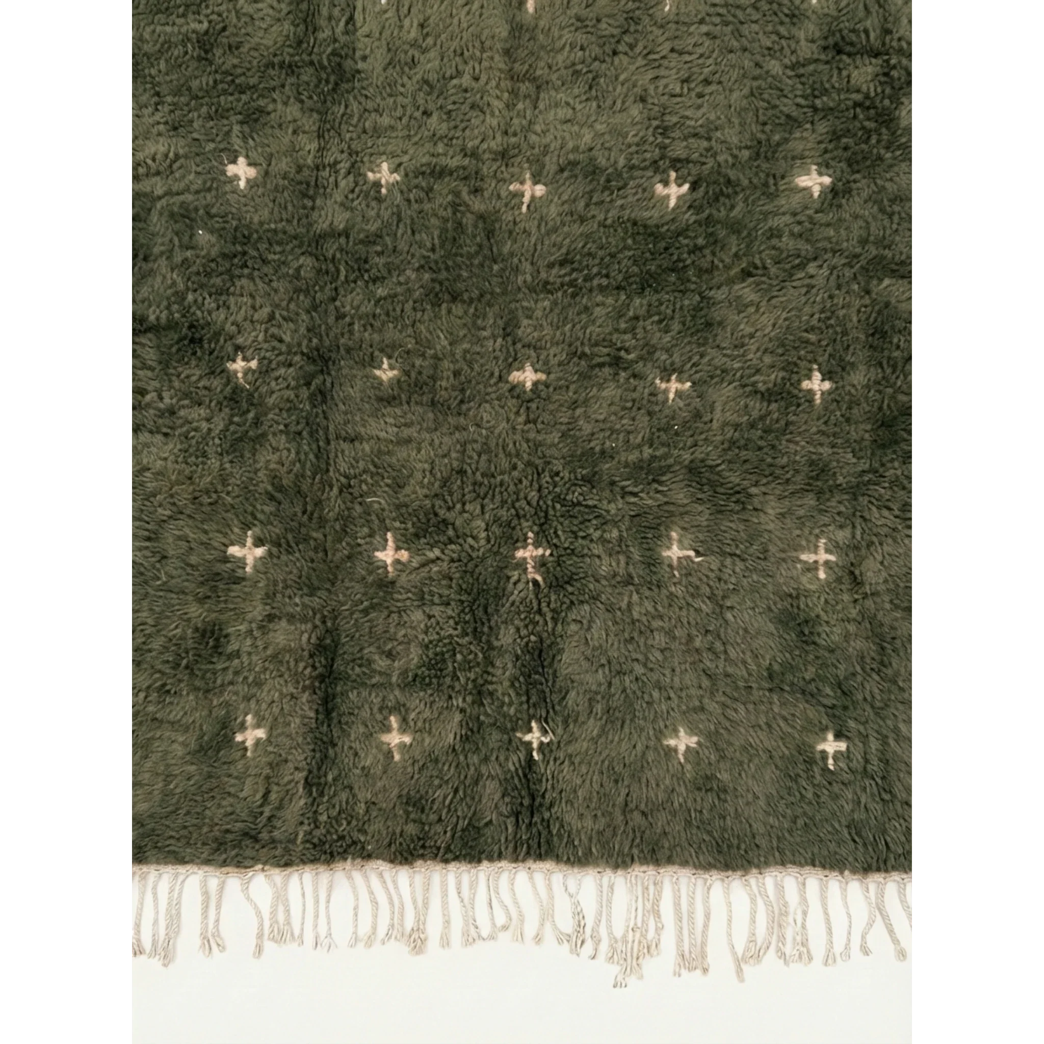 Detailed view of the ivory cross motifs across the Amnay green Moroccan rug.