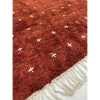 Hand-tied ivory fringe and terracotta pile detail of the Azru Beni Ourain rug.