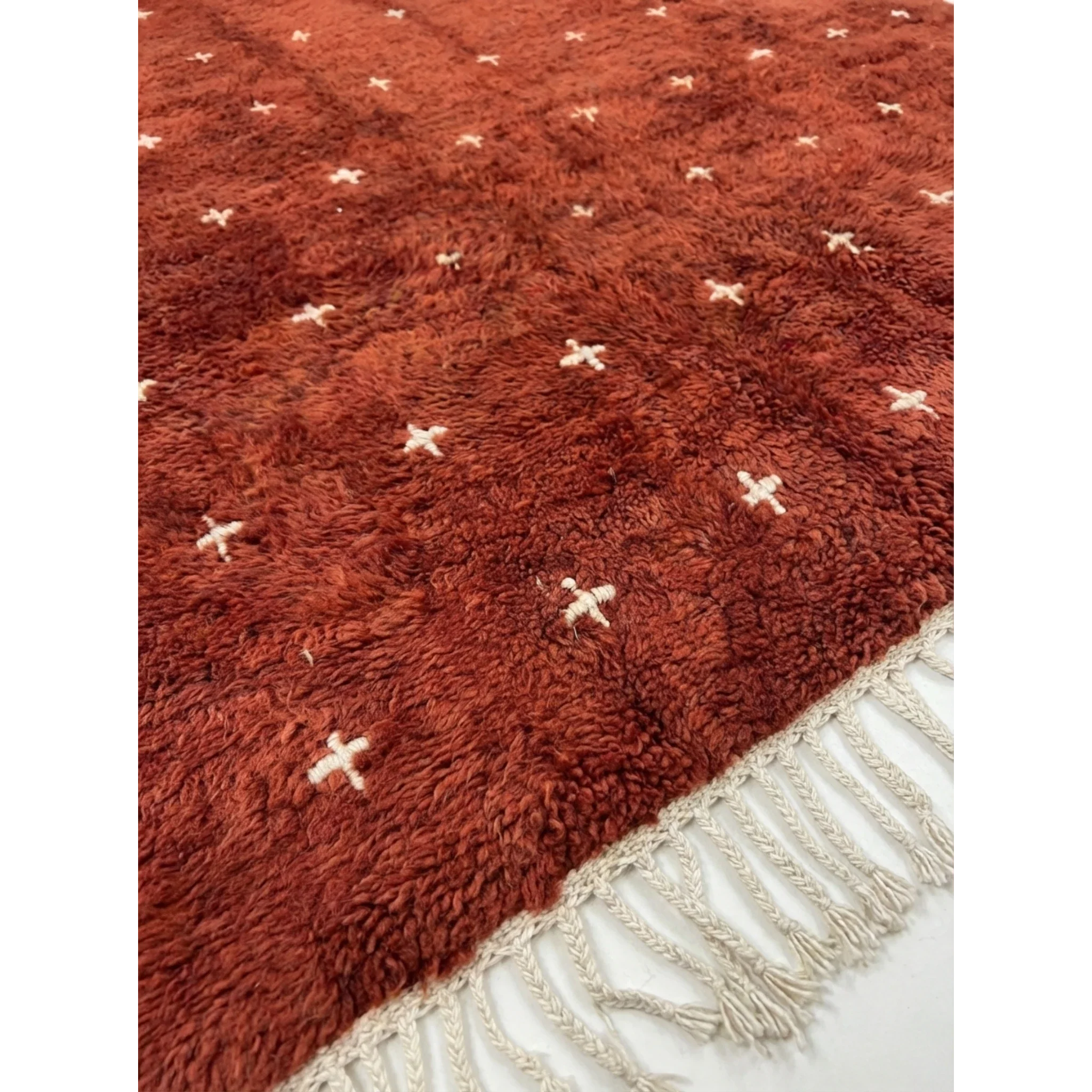 Hand-tied ivory fringe and terracotta pile detail of the Azru Beni Ourain rug.