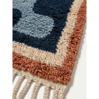 Fringe corner of the Azul navy blue Beni Ourain rug with ivory and rust border accents.