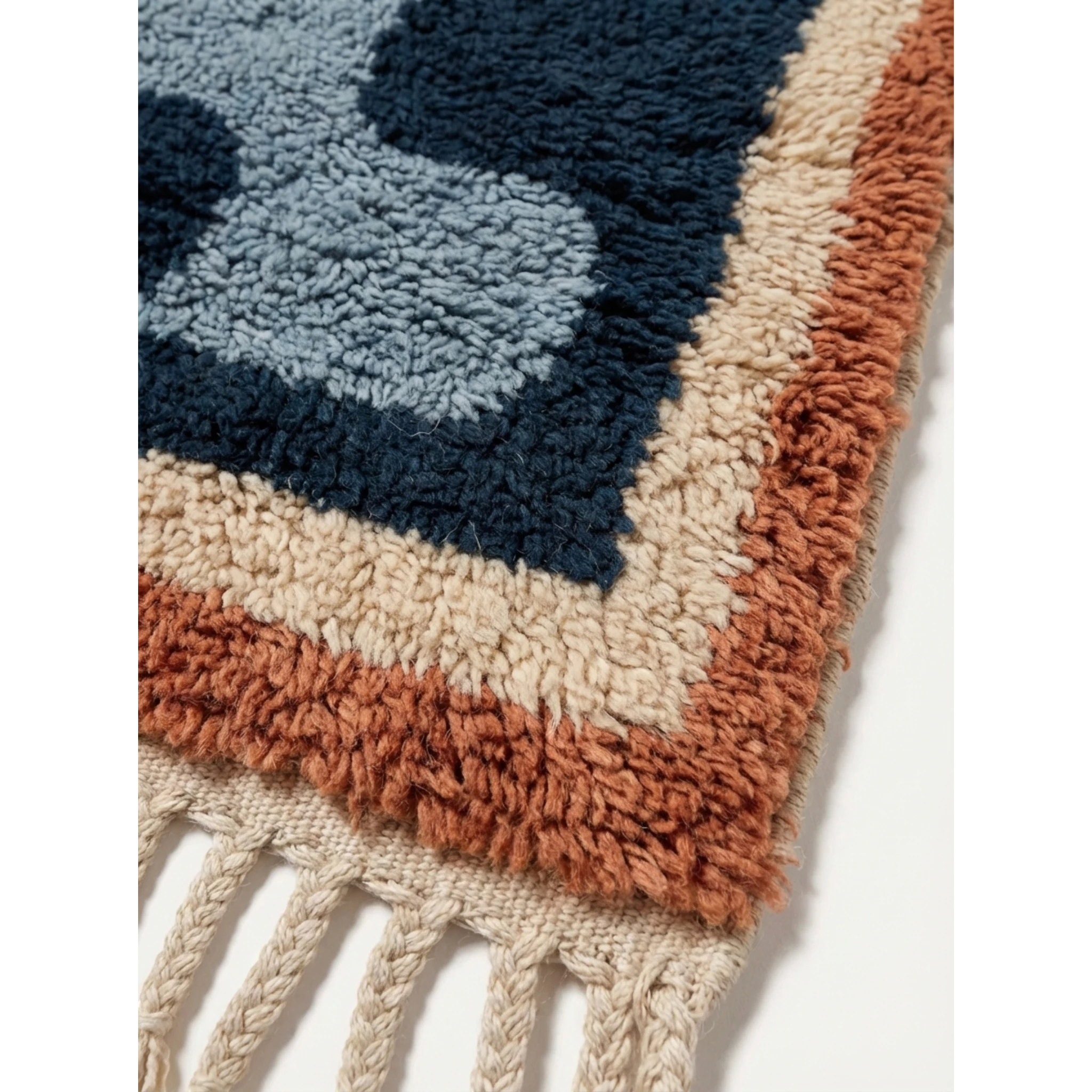Fringe corner of the Azul navy blue Beni Ourain rug with ivory and rust border accents.