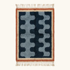 Full view of the Azul Beni Ourain rug with navy and blue abstract pattern, rust border and hand-tied fringe.