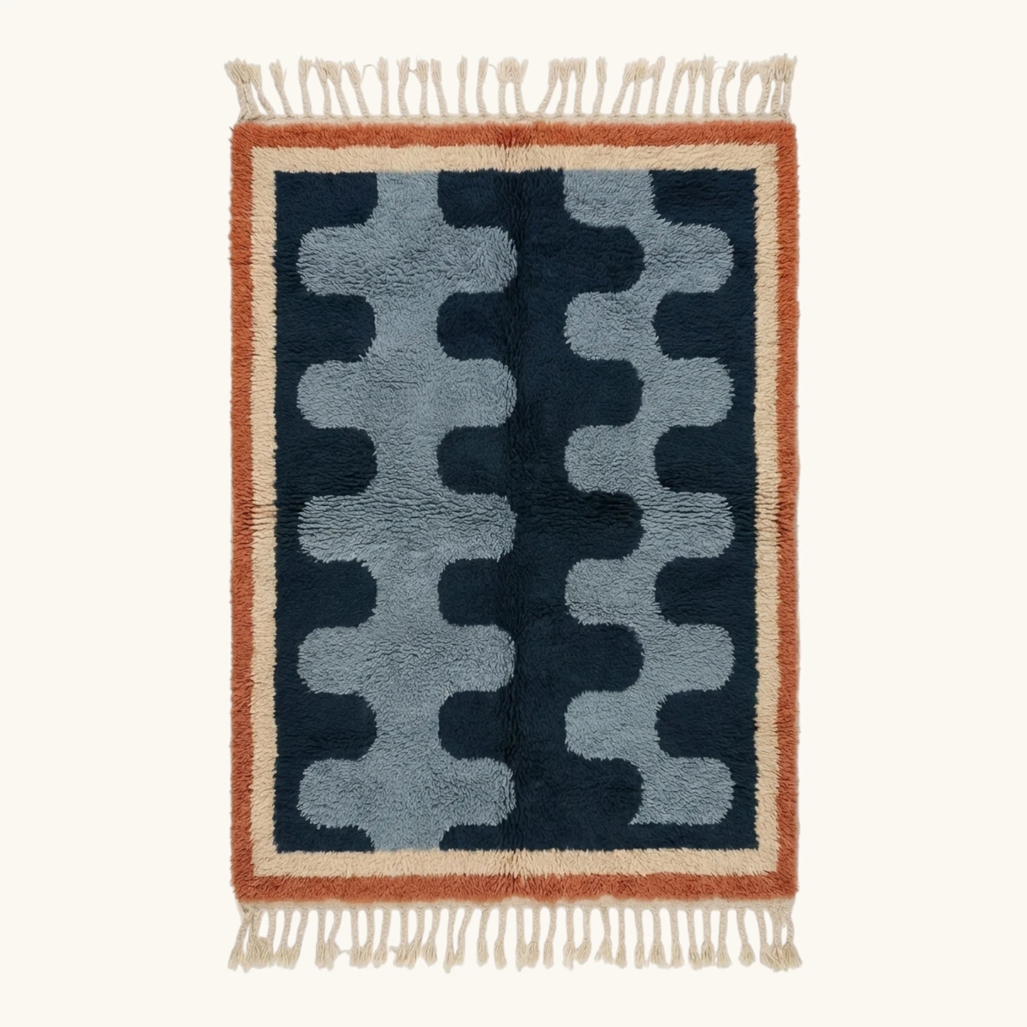 Full view of the Azul Beni Ourain rug with navy and blue abstract pattern, rust border and hand-tied fringe.