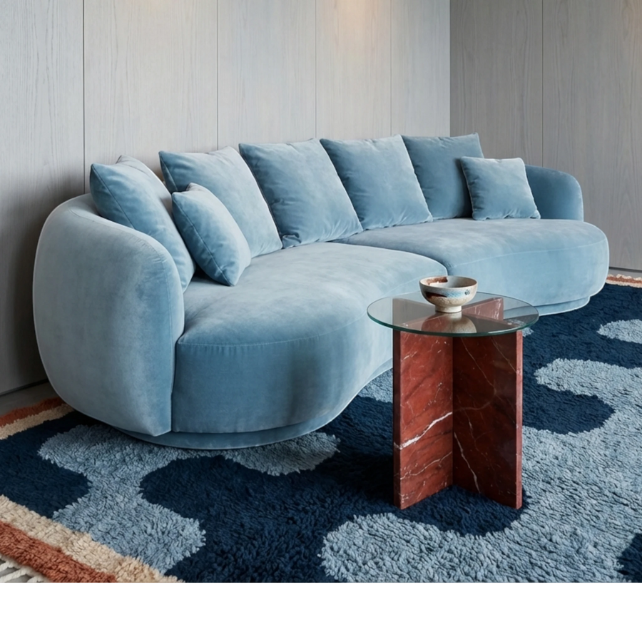 Azul navy blue Beni Ourain rug styled beneath a curved blue sofa in a contemporary living room.