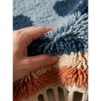 Hand lifting the thick wool pile of the Azul navy blue Beni Ourain rug to show its softness and density.