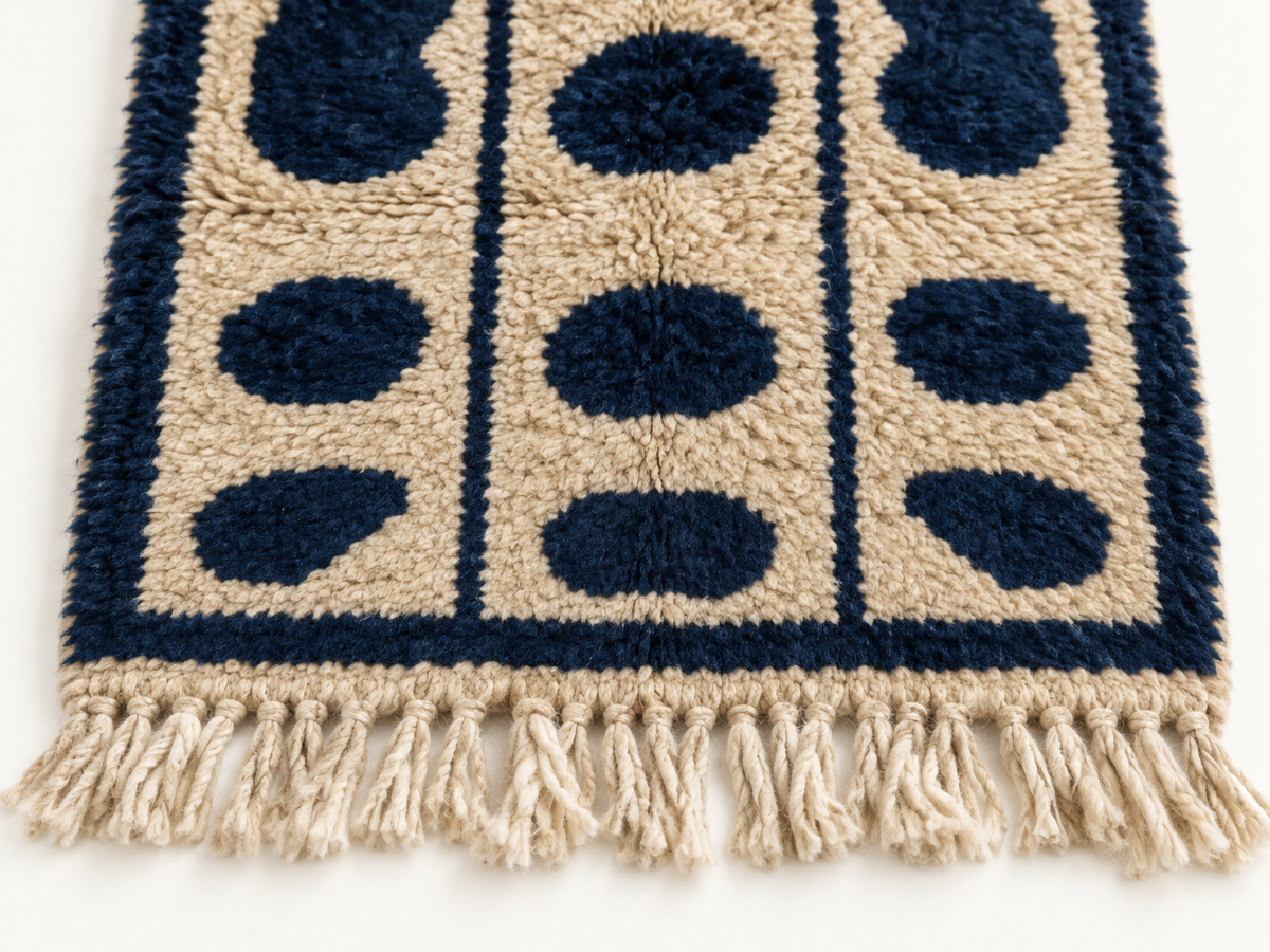 Beige and navy Mrirt runner end with natural wool fringe, showing pile and border detail