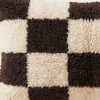 Side view of the Izem Moroccan pillow showing its black and ivory wool pile