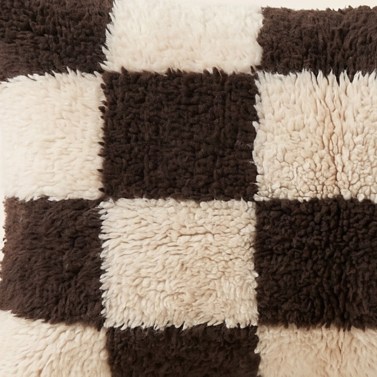 Side view of the Izem Moroccan pillow showing its black and ivory wool pile