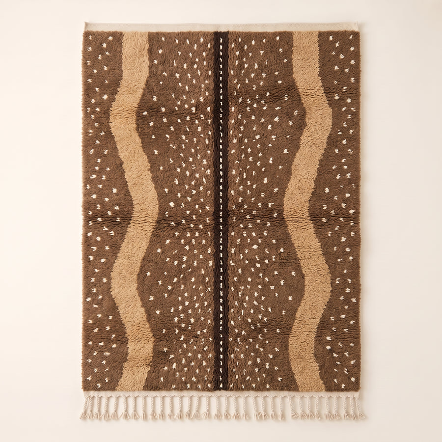 Fawn Beni Ourain rug with brown and ivory vertical speckled stripes and dark central line, flat view