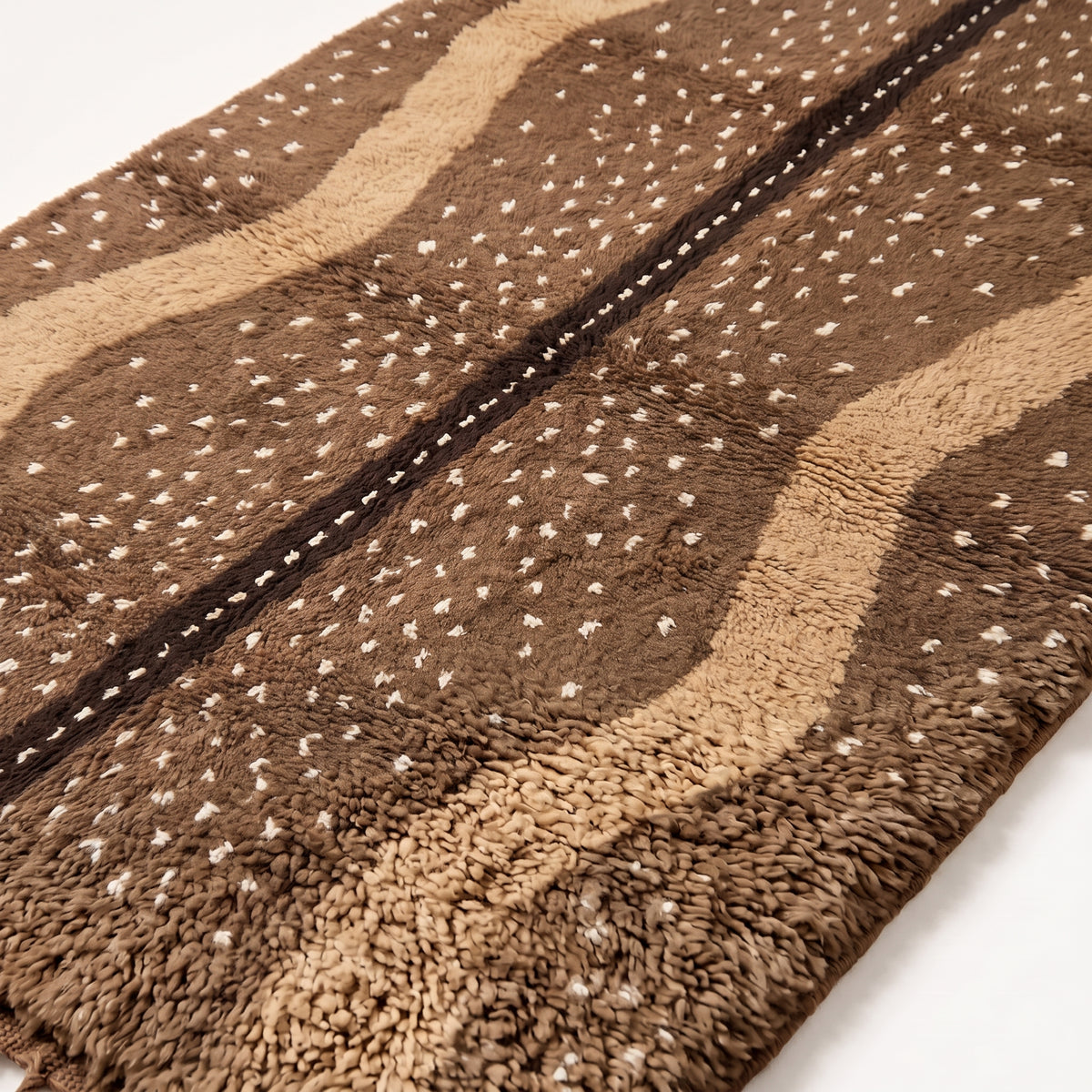 Close-up of speckled stripe pattern and thick wool pile texture on Fawn rug