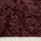 Cream-coloured fringe on burgundy Beni Ourain rug showing natural fibre texture