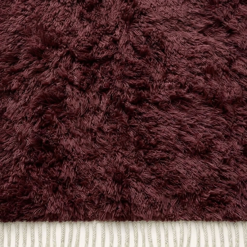 Cream-coloured fringe on burgundy Beni Ourain rug showing natural fibre texture
