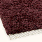 Close-up of burgundy wool pile texture and ivory fringe on Beni Ourain rug