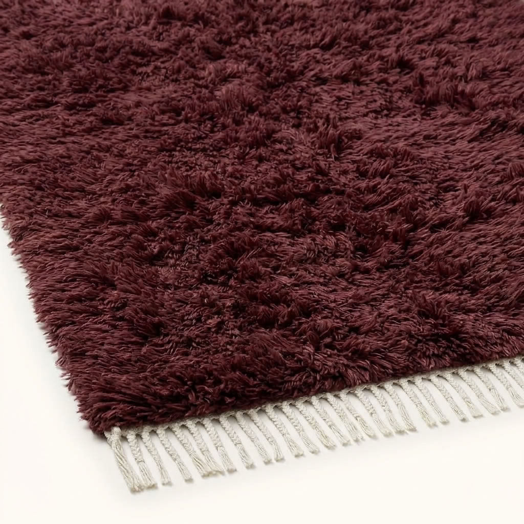 Close-up of burgundy wool pile texture and ivory fringe on Beni Ourain rug