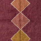Straight-on detail of cream-outlined diamonds in camel, rose, and gold tones