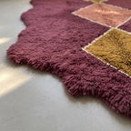 Angled detail shot showing gold diamond and burgundy pile depth