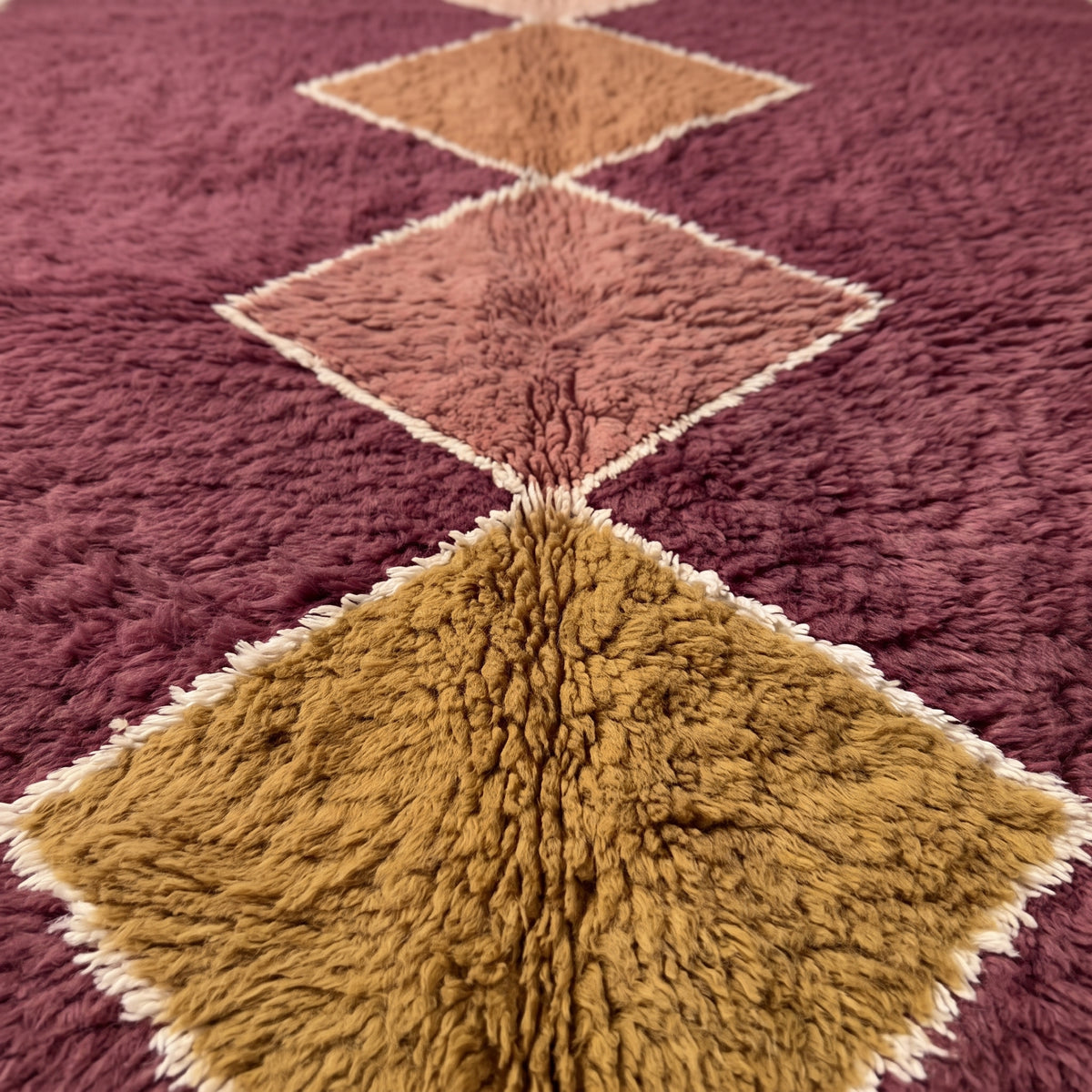 Close-up of stacked diamond motifs showing thick soft pile texture and cream outlines