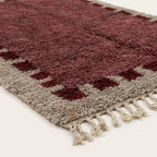 Close-up of the burgundy block border pattern on the Ziri ivory wool rug.