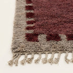 Angled view of the Ziri burgundy and ivory Beni Ourain rug.