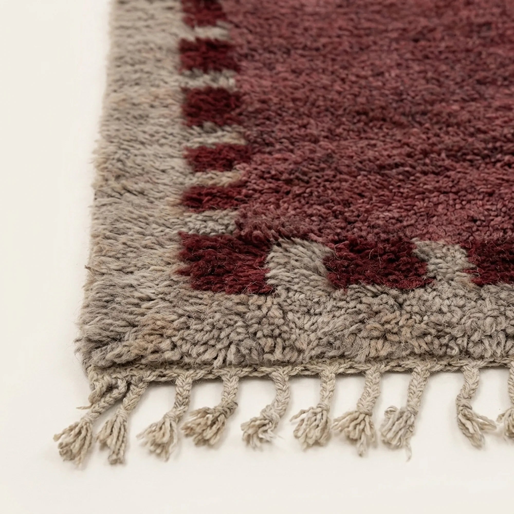 Angled view of the Ziri burgundy and ivory Beni Ourain rug.