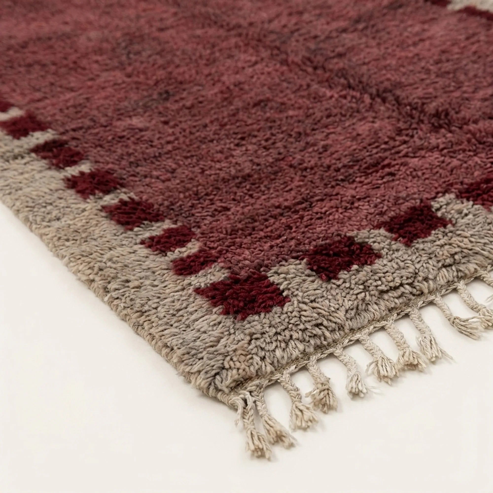 Fringe and edge detail of the Ziri burgundy and ivory Beni Ourain rug.