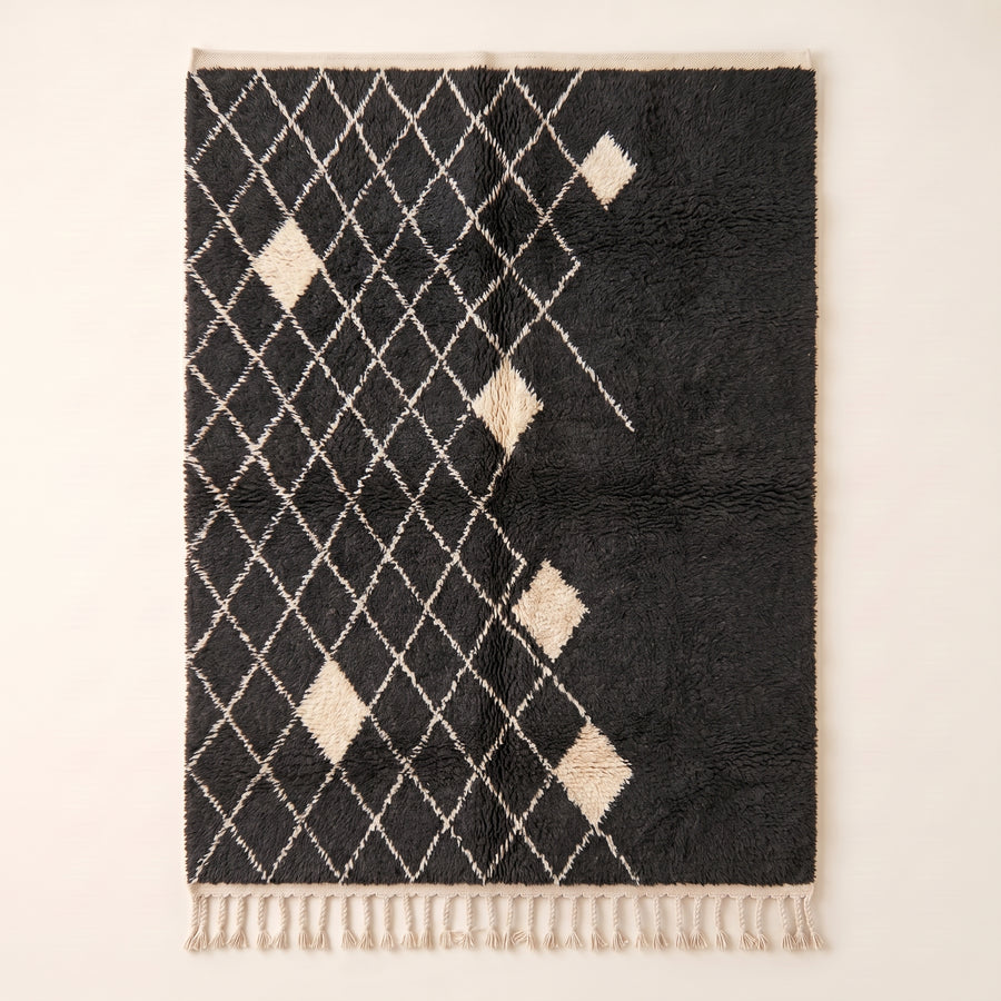 Charcoal and ivory Beni Ourain rug with diamond lattice pattern and scattered ivory diamond motifs, flat view on plain background
