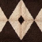 Detailed view of Massa's central diamond motif with brown outer frame, ivory inner diamond, and small black eye, showing wool knotwork