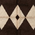 Overhead detail of Massa's diamond lattice pattern showing the contrast between chocolate brown and cream ivory wool knots