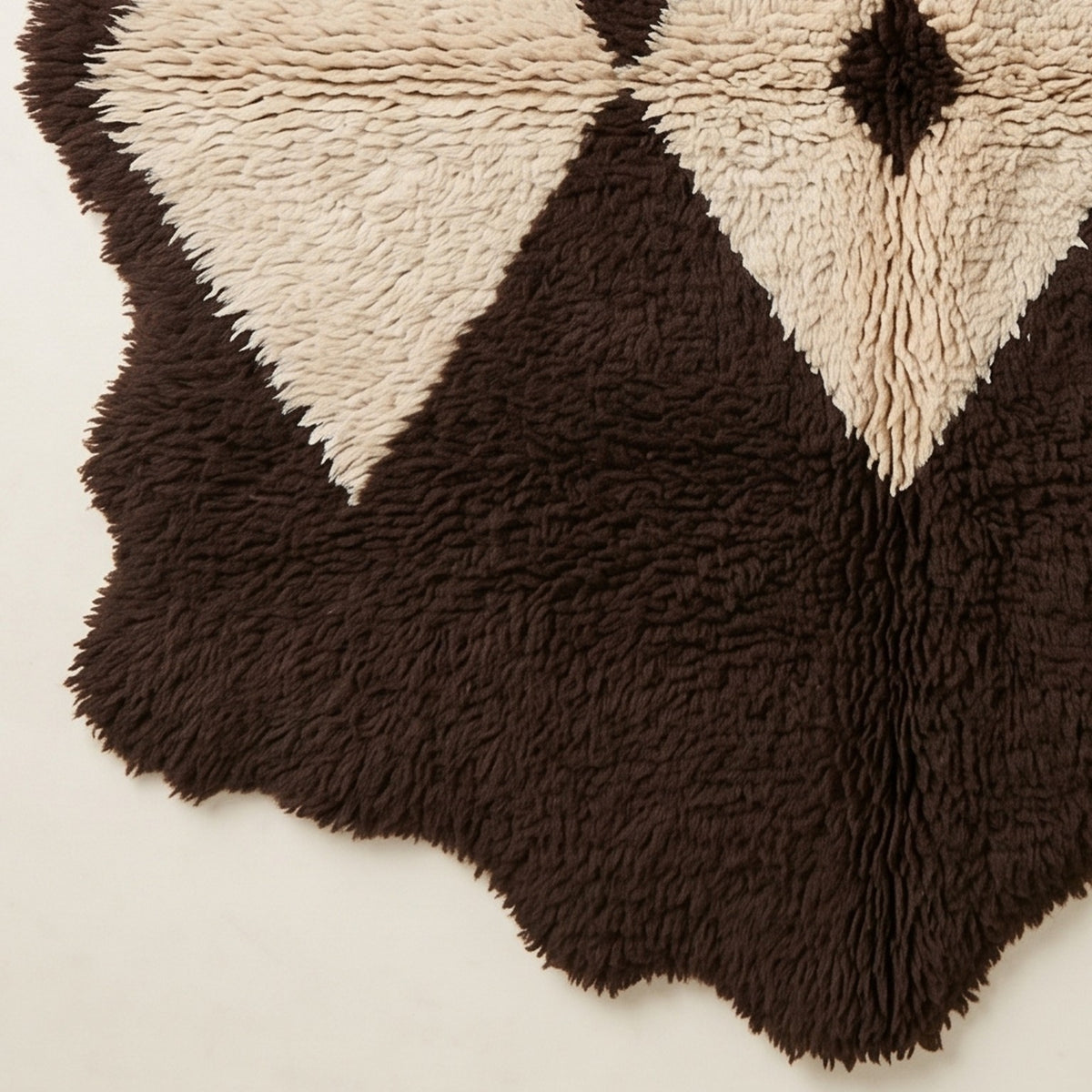 Edge detail of Massa showing irregular wavy border and fringe of the Beni Ourain rug in brown and ivory