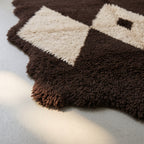 Textured close-up of Massa's hand-knotted wool showing the depth and quality of the pile in brown and ivory diamond sections