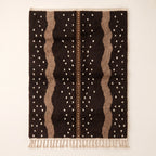 Chocolate and taupe Beni Ourain rug with scattered cream dots and wavy vertical columns on plain background