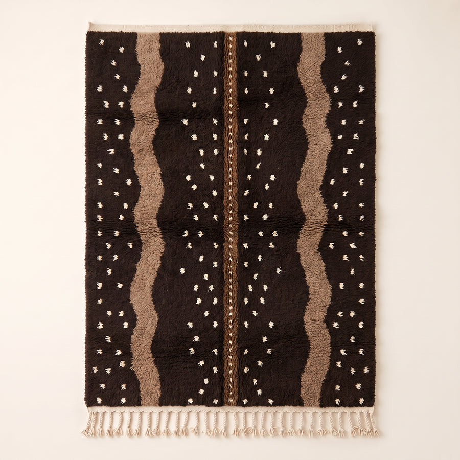 Chocolate and taupe Beni Ourain rug with scattered cream dots and wavy vertical columns on plain background