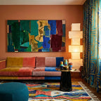Izuran Boujaad rug styled in a living room with its coral, mustard and teal vertical diamond design visible