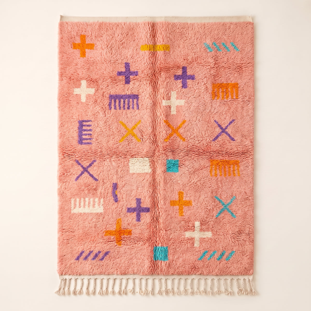 Coral Azilal rug with hand-drawn script and symbol scatter in purple, gold, turquoise, cream and white, photographed flat on plain background